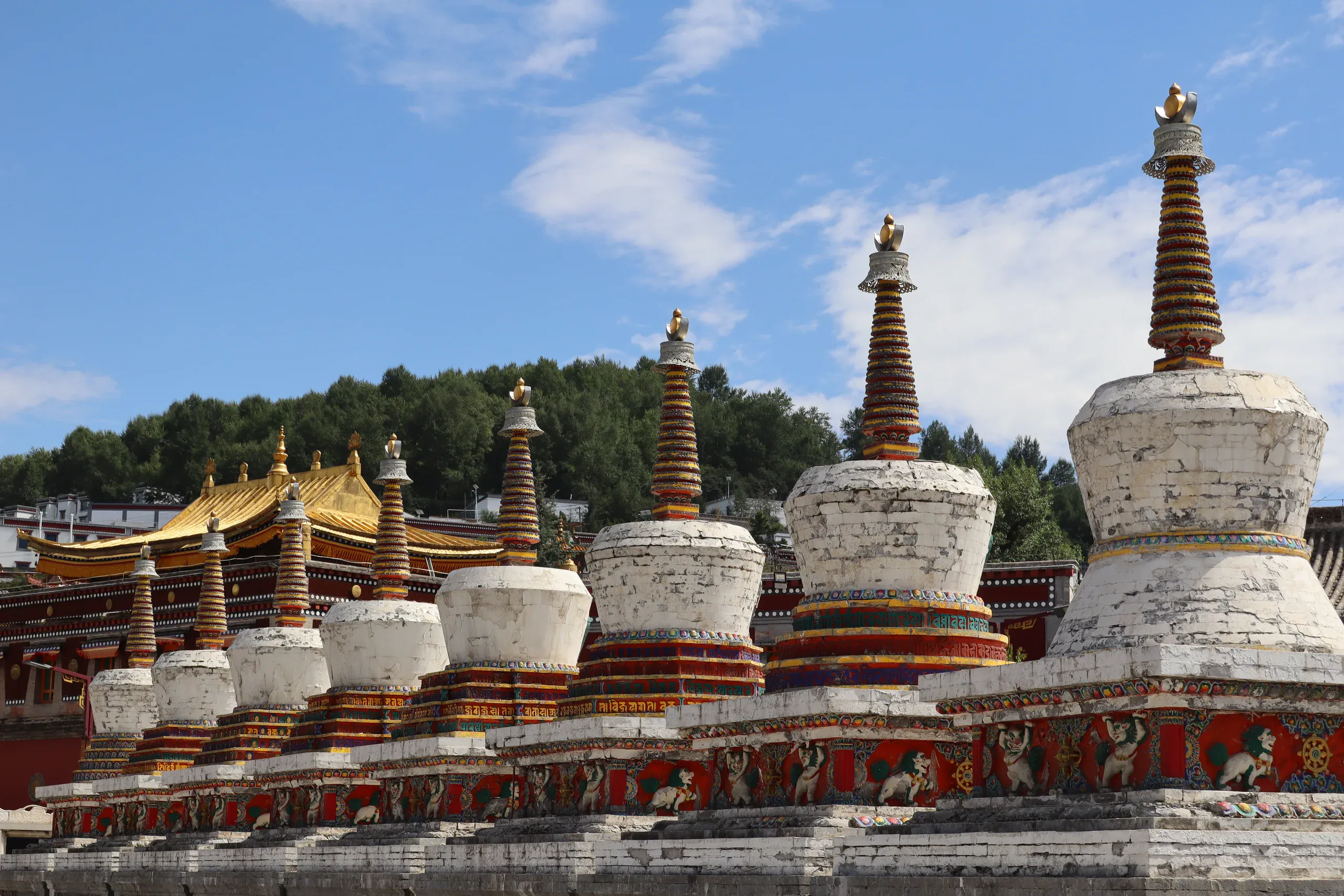 蓝天下的白色佛塔与彩绘寺院建筑